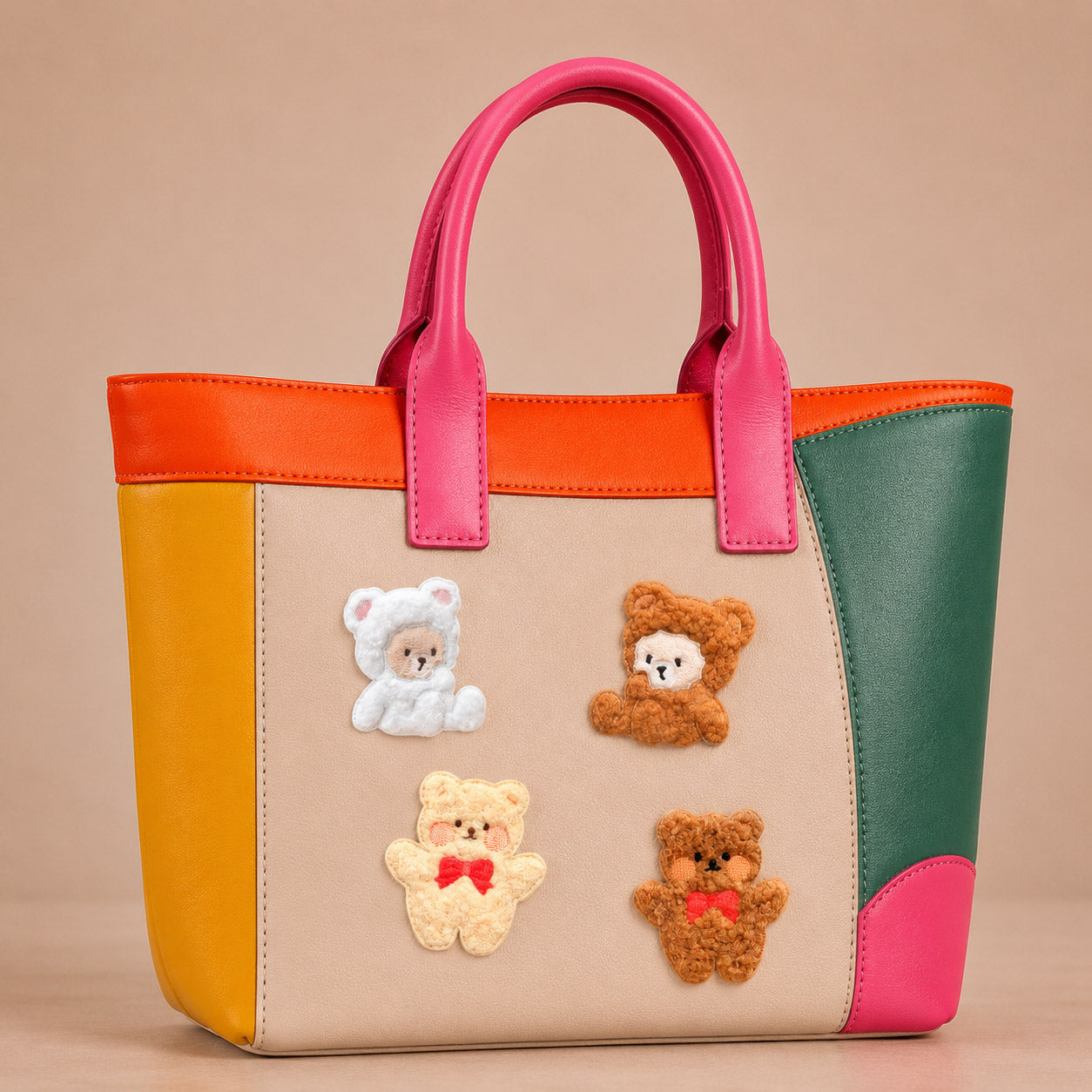 plush white and brown teddy bear with red bow stick-on patches decorating a pink and orange color-block leather handbag