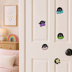 ghibli soot sprite reading purple blue green pink and yellow books stick-on patches displayed on a white bedroom door