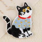curious tuxedo cat in blue sweater embroidered patch close-up detail