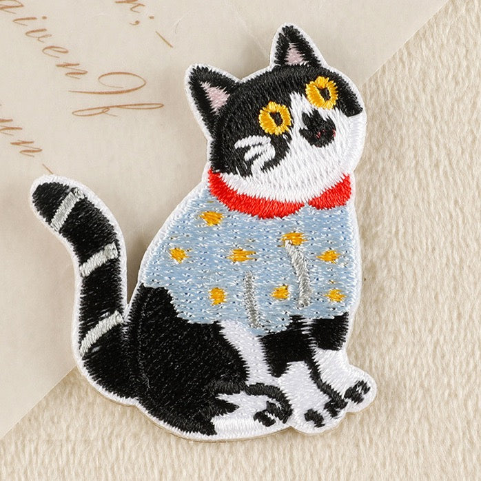 curious tuxedo cat in blue sweater embroidered patch close-up detail