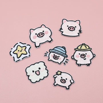Seven embroidered stick-on patches featuring five pink piglets, a yellow star, and a smiling cloud
