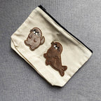 cute seal embroidered patches on a natural canvas pouch