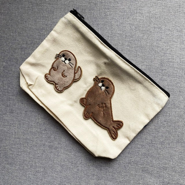cute seal embroidered patches on a natural canvas pouch