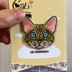 animated hand holding packaged famous cat breeds embroidered patches showing seven styles and detailed embroidery texture