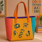cartoon duck on sofa in top hat and stacking stick-on patches decorating an orange and yellow color-block leather handbag