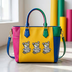 three matching gray striped cat patches with wide eyes and raised paws on a colorful leather handbag