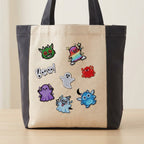 seven spooky cute halloween ghost and monster embroidered patches on a cream and charcoal canvas tote bag