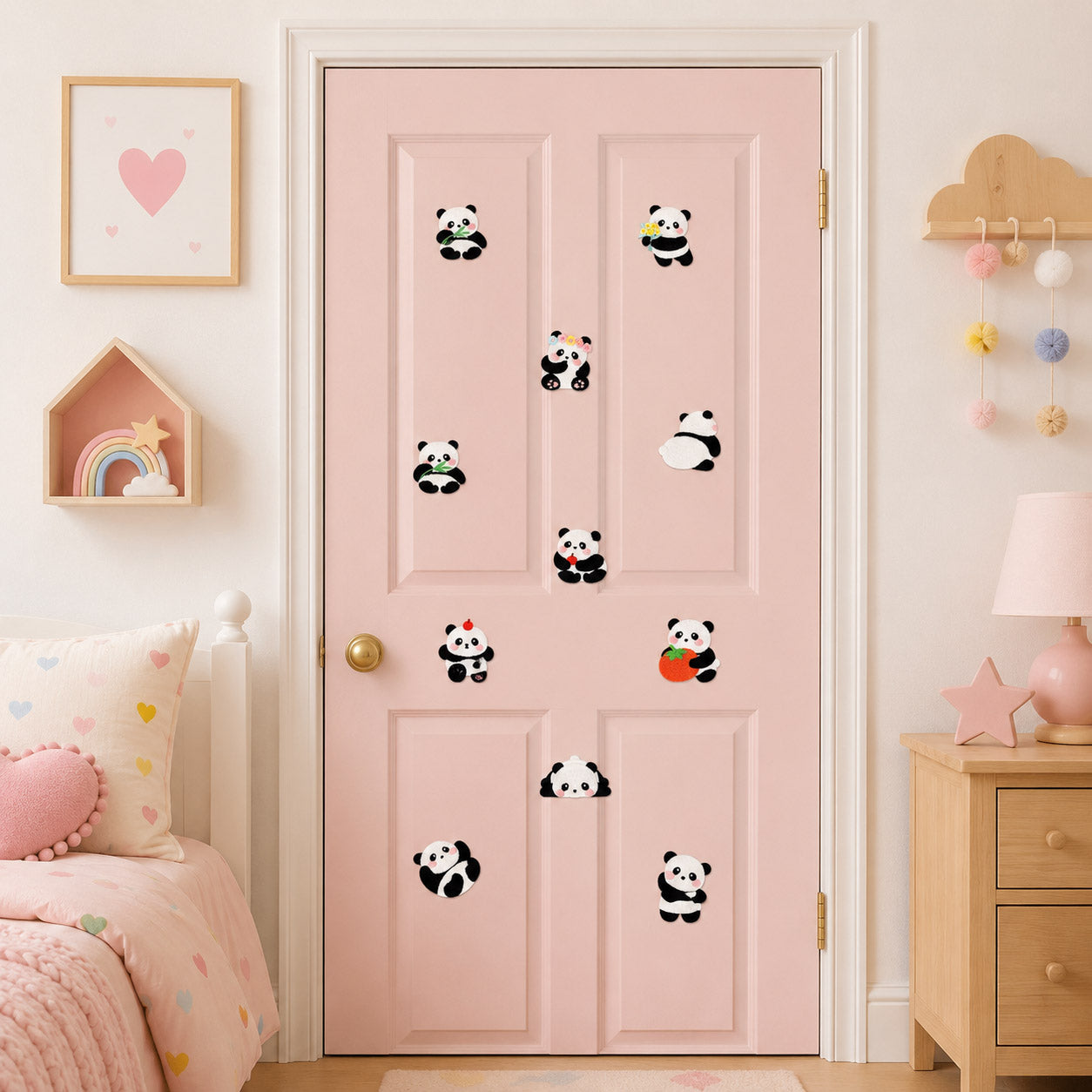 eleven adorable panda embroidered patches in various poses scattered on a pink door in a pastel girls bedroom