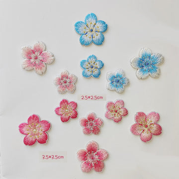 Twelve cherry blossom embroidered patches in six pink and blue colorways, each with a matching large and small flower
