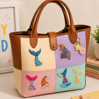 sparkly mermaid tail stick-on patches in mixed colors decorating a soft color-block leather handbag