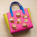 seven red panda patches licking paw holding flowers hugging strawberry and waving on a bold color-block bag