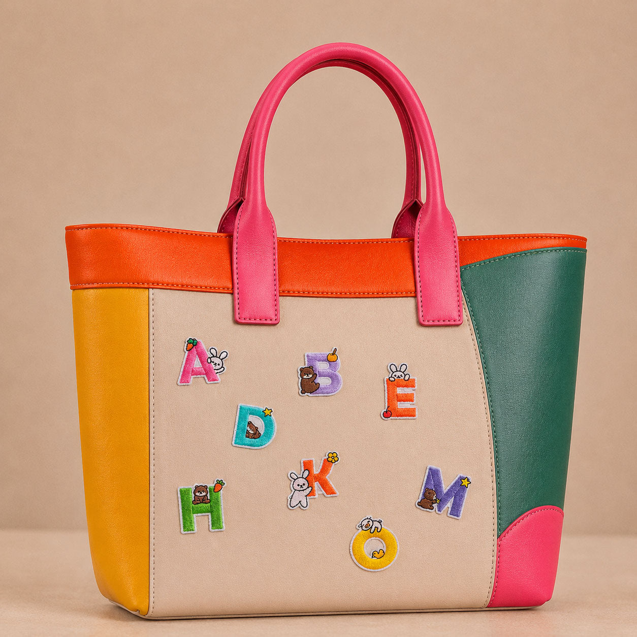 colorful alphabet letters with bunny bear and otter stick-on patches decorating a pink and orange color-block leather handbag