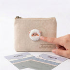 fluffy alpaca embroidered patch being pressed onto a natural linen coin purse