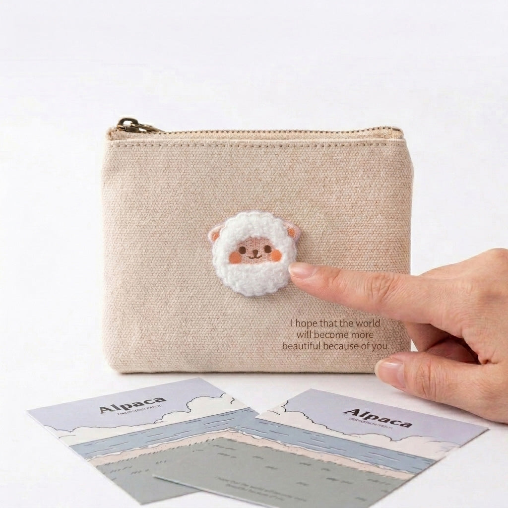 fluffy alpaca embroidered patch being pressed onto a natural linen coin purse