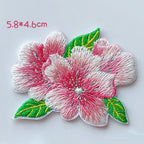 Twin cherry blossoms with green leaves embroidered patch measuring approximately 58 by 46 mm
