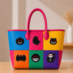 nine halloween embroidered patches on a bold color-block leather tote bag