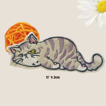 grumpy grey tabby cat lying flat with yellow green eyes embroidered stick-on patch