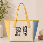Funny cat embroidered stick-on patches decorating a tote bag with yellow handles
