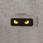 yellow glow-in-the-dark cat eye embroidered stick-on patch on black background