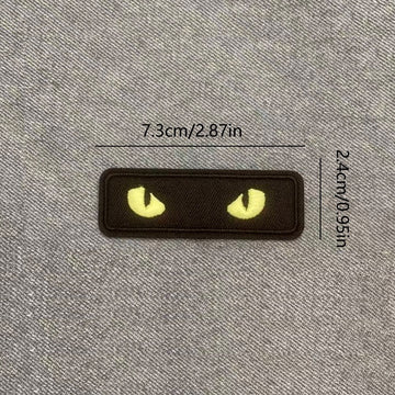 yellow glow-in-the-dark cat eye embroidered stick-on patch on black background
