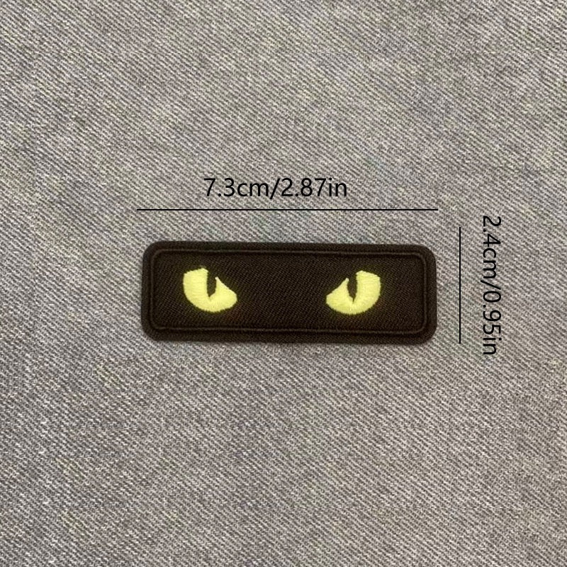 yellow glow-in-the-dark cat eye embroidered stick-on patch on black background