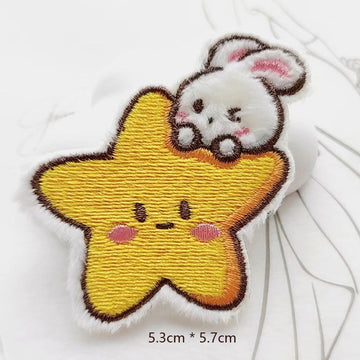 white bunny on yellow smiling star embroidered stick-on patch — bunny draped over star with both arms fluffy raised embroidery 53x57mm
