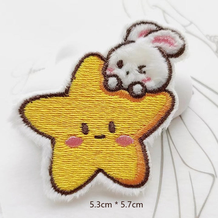 white bunny on yellow smiling star embroidered stick-on patch — bunny draped over star with both arms fluffy raised embroidery 53x57mm