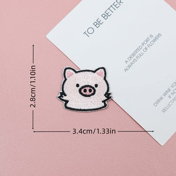 Waving pink piglet embroidered stick-on patch with rosy cheeks and a tilted pose
