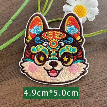 Chinese zodiac dog embroidered stick-on patch — opera face-paint style with layered fur texture orange and teal forehead markings star eyes