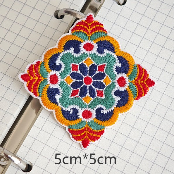 Diamond-shaped floral embroidered stick-on patch with red pointed accents
