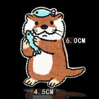 standing otter holding blue fish with fish on head embroidered stick-on patch