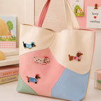 dachshund in crown with striped sweater heart shirt and spotted coat stick-on patches decorating a pink and cream wave color-block leather handbag