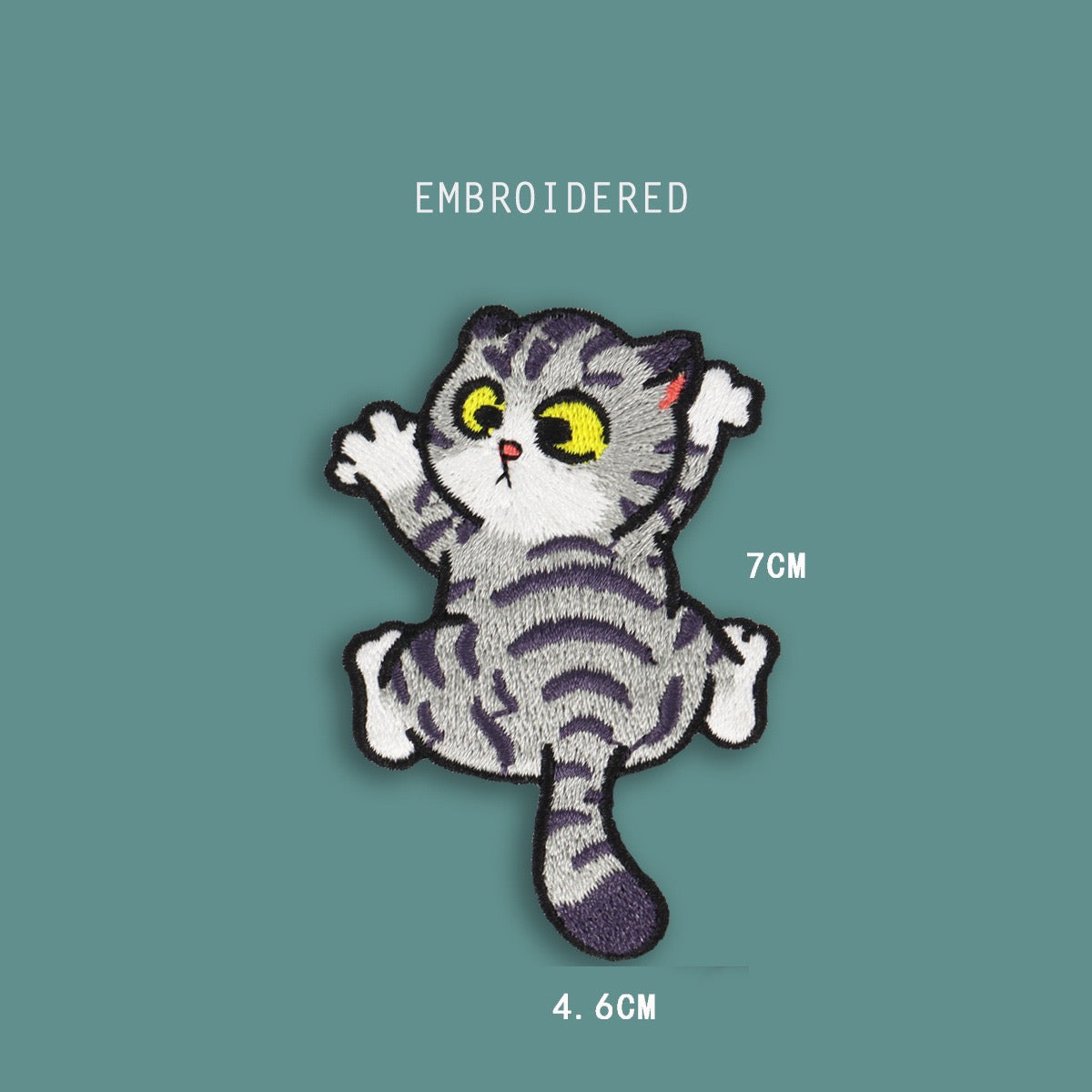climbing front cat embroidered stick-on patch — grey tabby face-on with large yellow eyes white chest and four splayed paws mid-climb