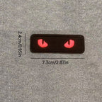 red glow-in-the-dark cat eye embroidered stick-on patch on black background