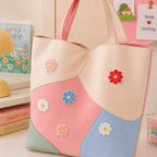 pink red blue white and peach cosmos flower stick-on patches scattered on a pink and cream wave color-block leather handbag