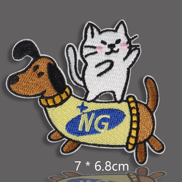 dachshund in yellow NG vest with white cat riding on its back embroidered patch