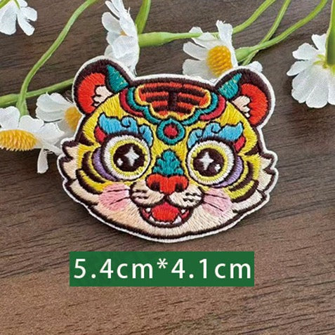 Chinese zodiac tiger embroidered stick-on patch — orange red stripes bold forehead markings intense expression opera style