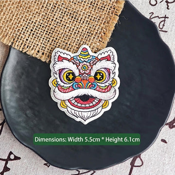 pink floral Chinese lion dance embroidered stick-on patch — soft purple pink face with crescent blue eyes floral geometric forehead motifs round dreamy silhouette