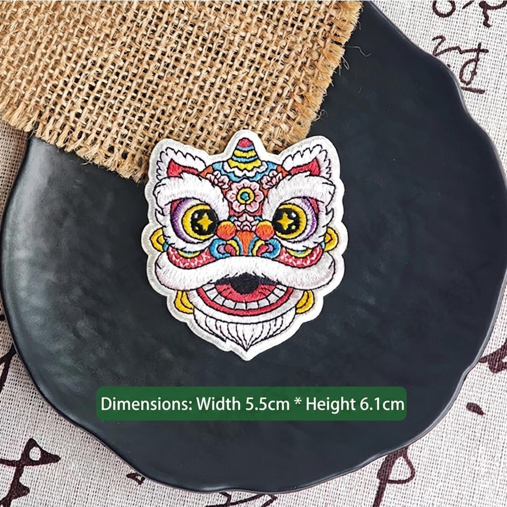 pink floral Chinese lion dance embroidered stick-on patch — soft purple pink face with crescent blue eyes floral geometric forehead motifs round dreamy silhouette