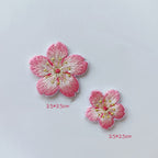 Large and small cherry blossom patches with pink petal edges, creamy centers, and gold-tone stamens
