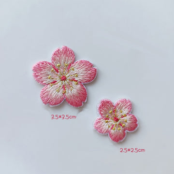 Large and small cherry blossom patches with pink petal edges, creamy centers, and gold-tone stamens
