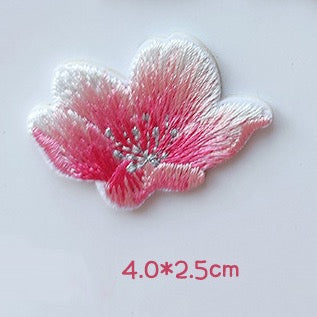 Side-view pink cherry blossom embroidered patch with upward-curving petals and silver-tone stamens

