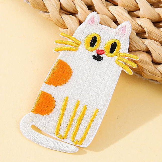 sitting white and ginger calico derpy cat embroidered patch close-up detail