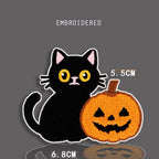 black cat with jack-o-lantern pumpkin embroidered stick-on patch — black cat sitting beside carved orange halloween pumpkin with grinning face