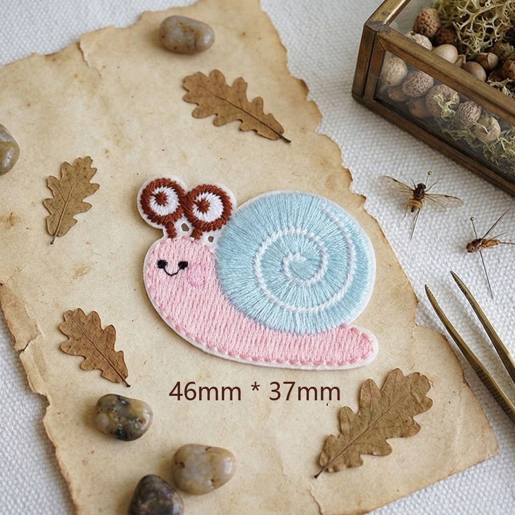 pastel pink snail with pastel blue spiral shell cottagecore embroidered stick-on patch