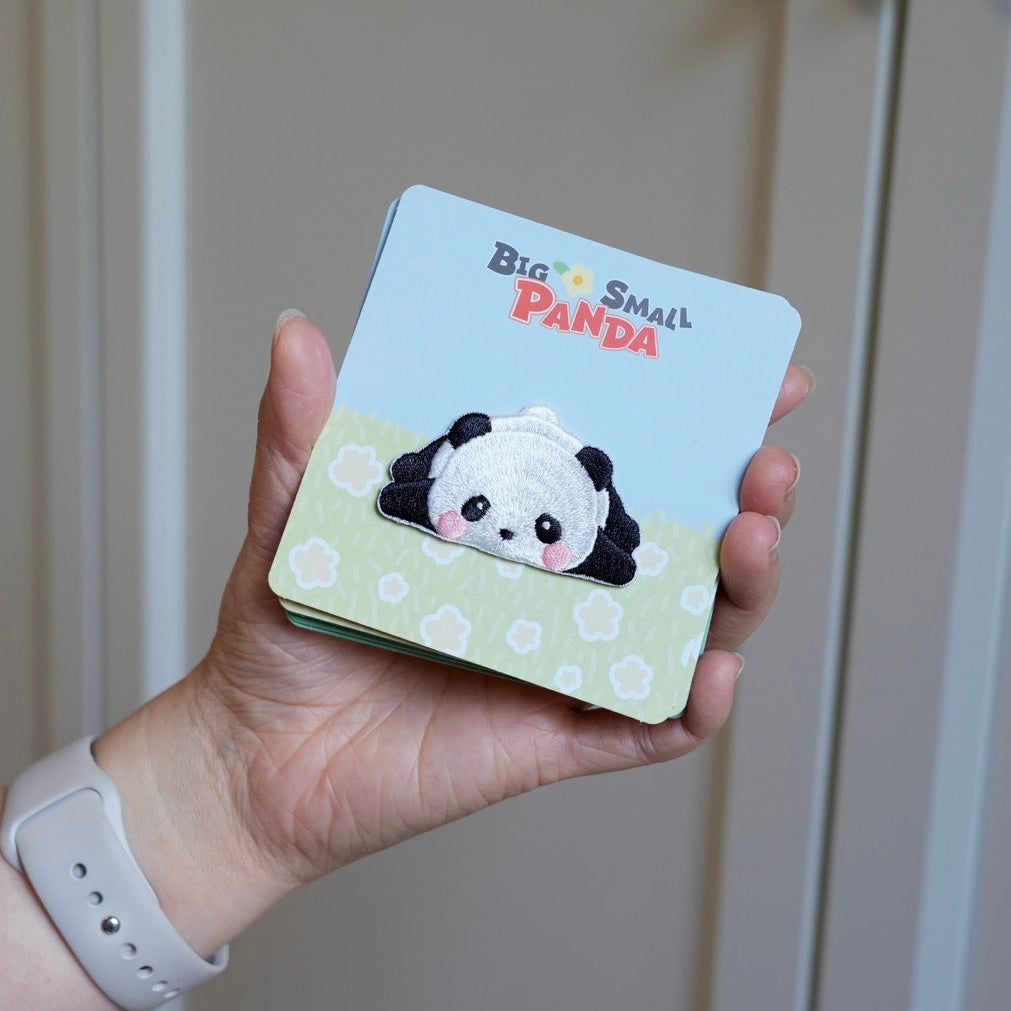holding an adorable giant panda embroidered stick-on patch in hand