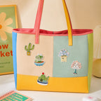 cactus and succulent in heart pot round bowl and cute character planter stick-on patches decorating a multicolor stripe leather handbag