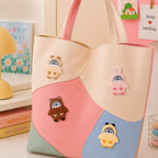 fluffy penguin dressed as panda bunny bear and chick stick-on patches decorating a pink and cream wave color-block leather handbag
