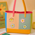 large floral bloom patches with ditsy print petals in yellow pink blue and green borders decorating a multicolor stripe leather handbag