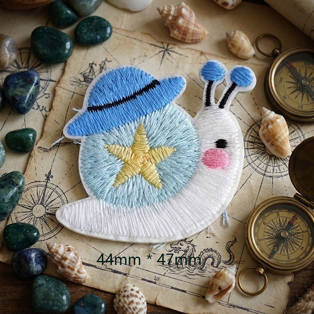 white snail with blue sun hat and gold star cottagecore embroidered stick-on patch